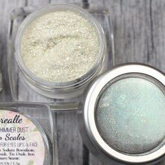 Close-up of green holographic shimmer dust eyeshadow with sparkling glitter particles in a sleek round compact.