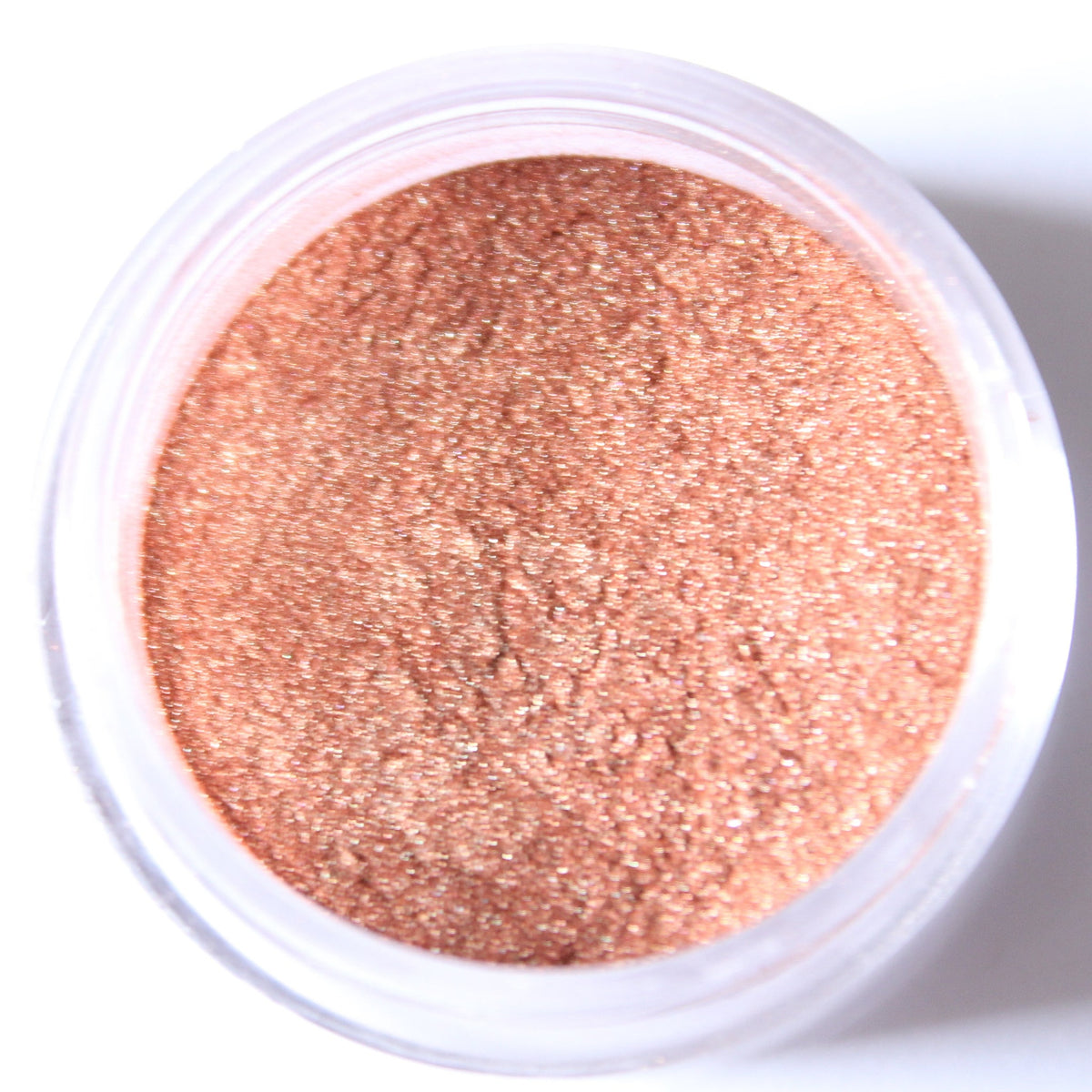 Glass jar of loose mineral eyeshadow in shimmering rose gold with metallic finish, lid removed