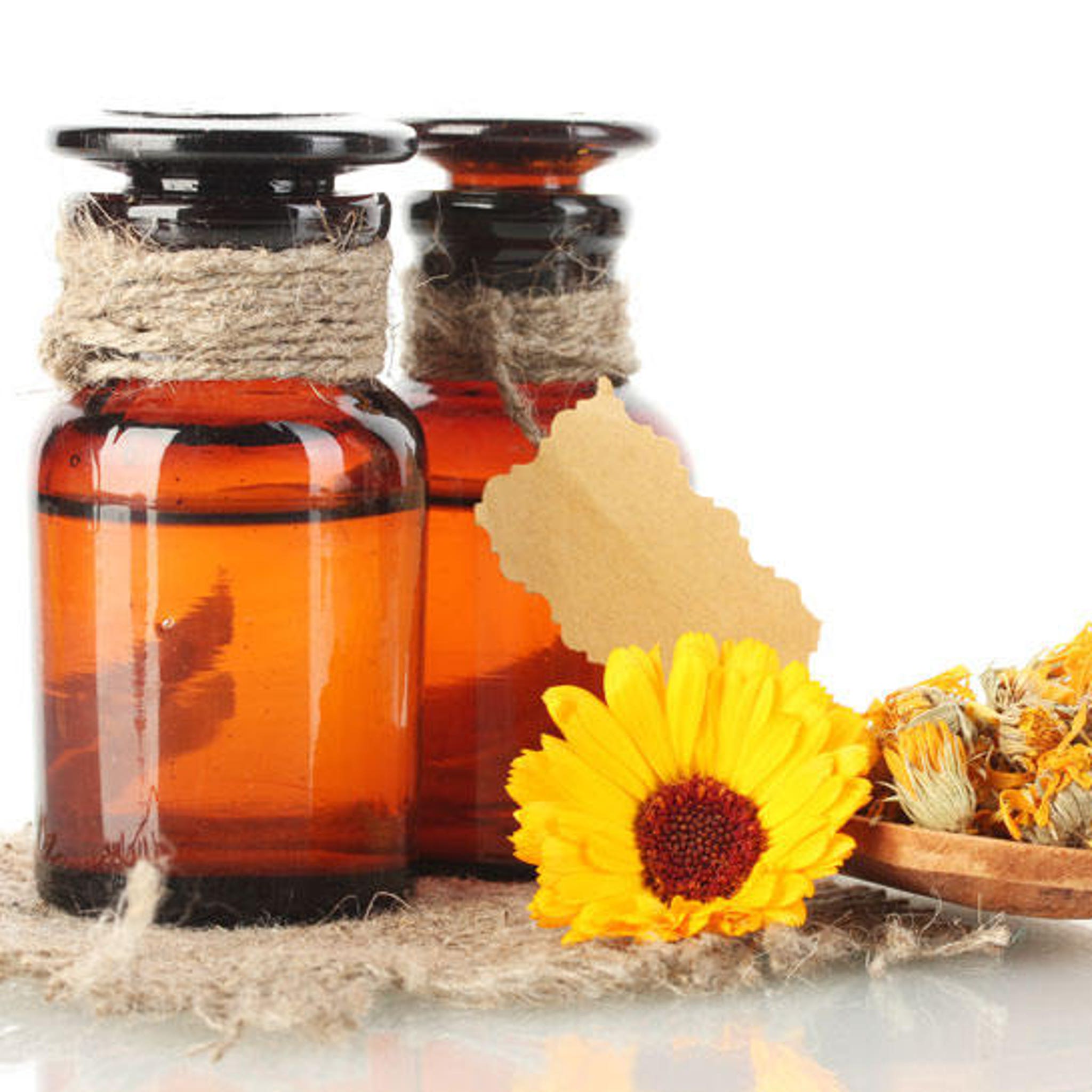 Amber glass bottles with rope detail, yellow flower and dried herbs on burlap