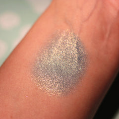 Close-up of a makeup brush applying shimmering teal Atlantis Eye Shadow to eyelid.
