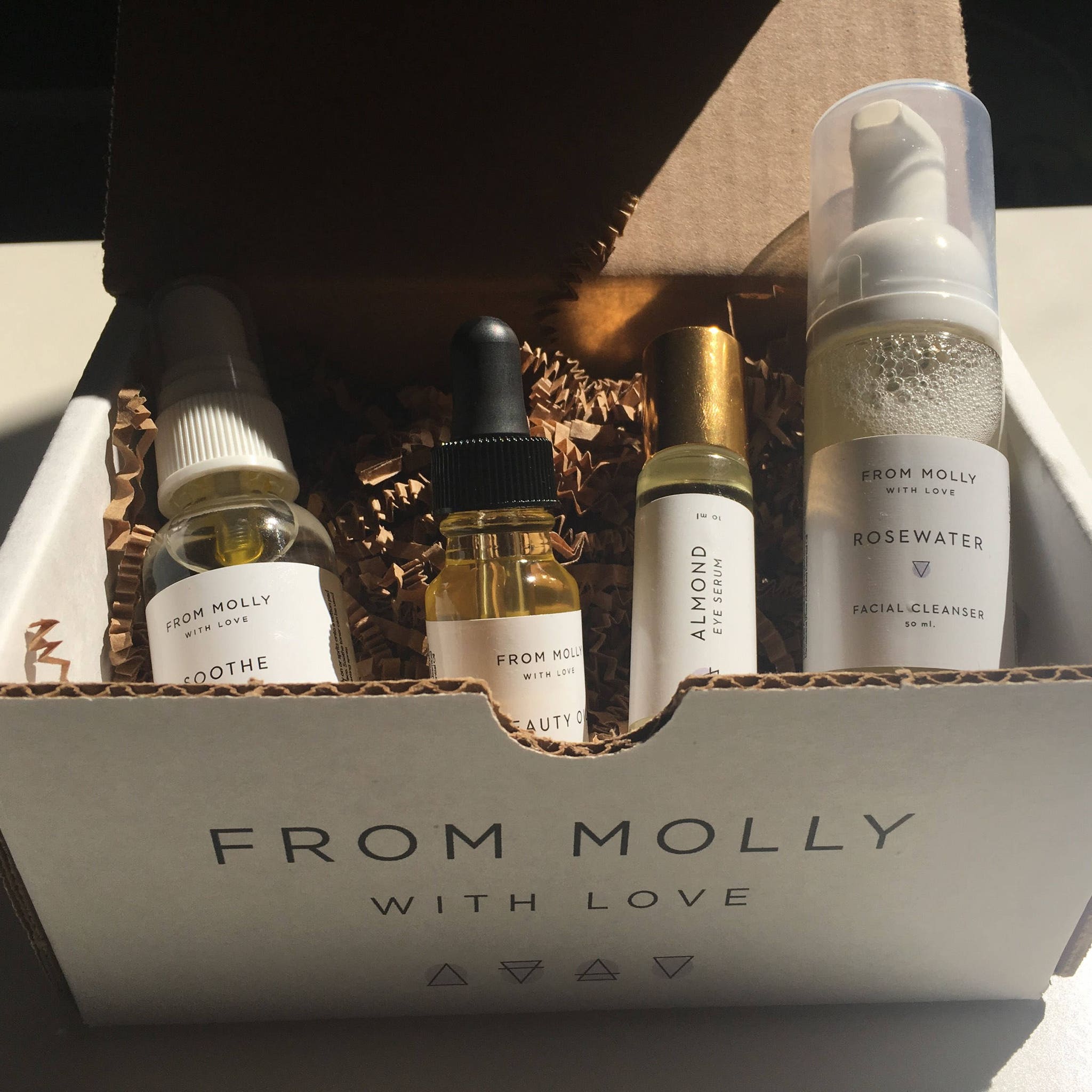 Skincare set with clear glass bottles, white labels, and "From Molly With Love" text in a box