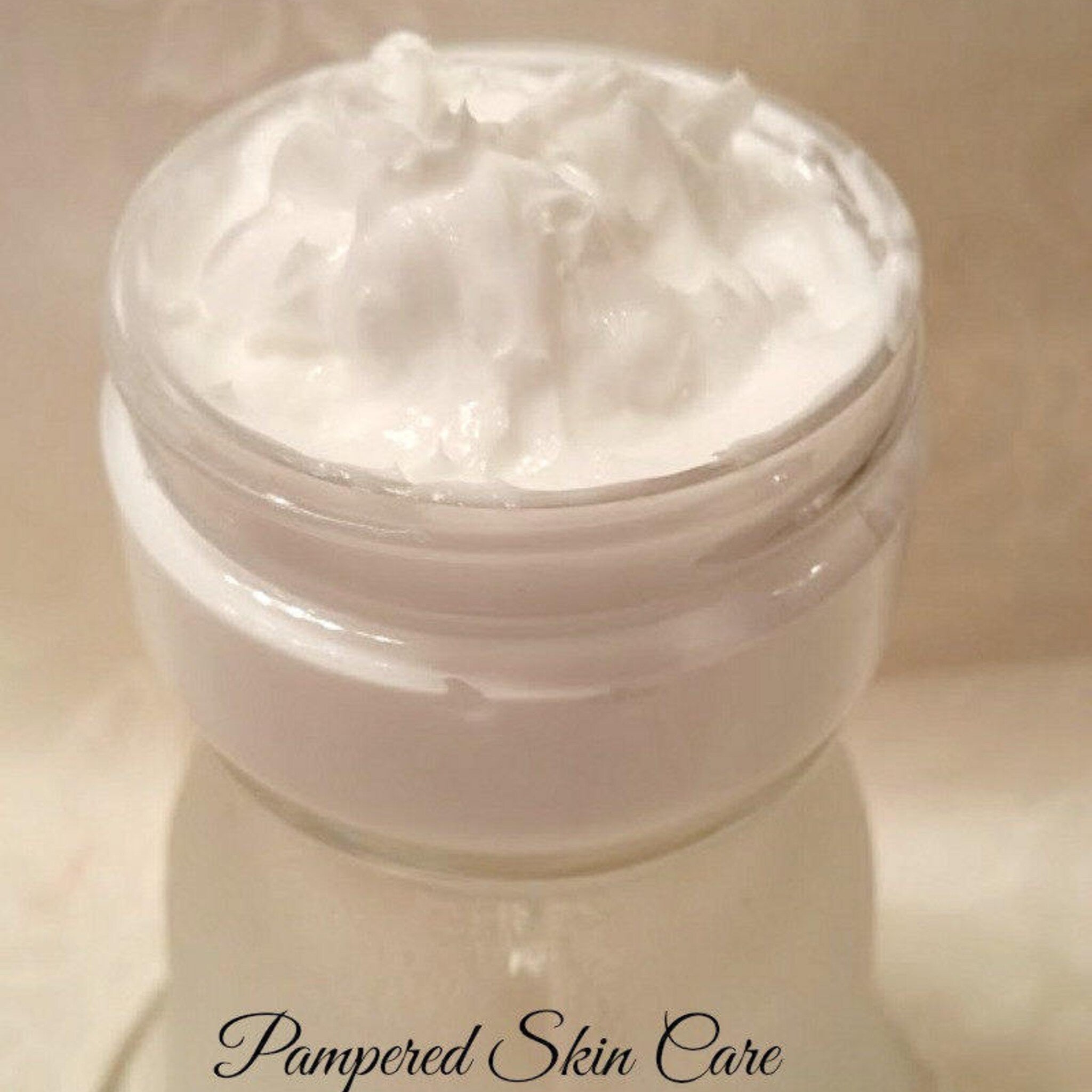 Close-up of golden turmeric cream with rich texture in sleek white jar, showcasing luxurious skincare product