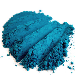 Close-up of matte teal loose eyeshadow powder with dark peacock turquoise hue, vegan mermaid collection