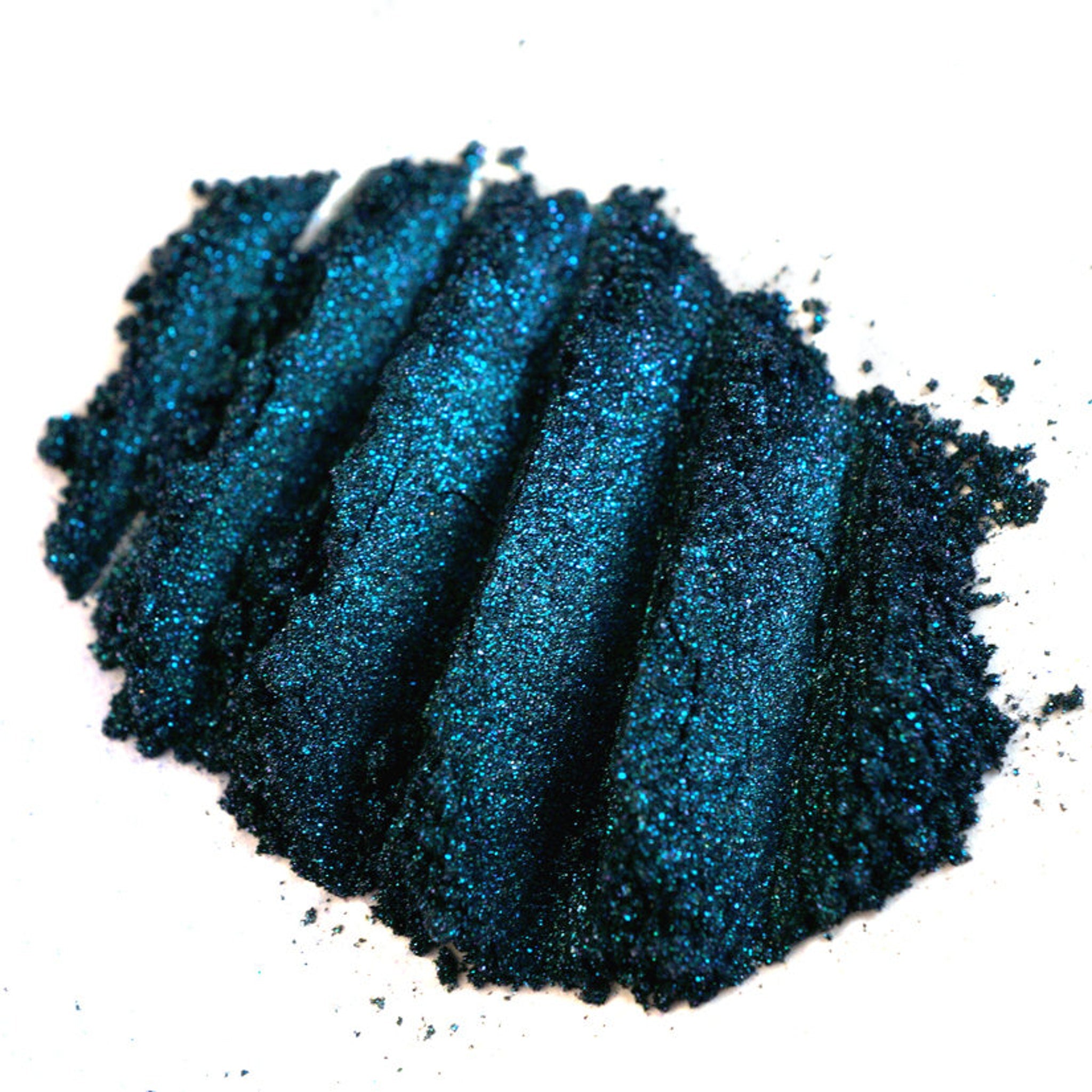 Close-up of iridescent teal eyeshadow with colorshifting glitter particles in mermaid-inspired turquoise hues