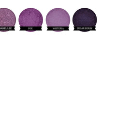 Close-up of fingertips applying indigo matte mineral eyeshadow to eyelid with smooth blending motion