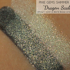 Side view of green holographic shimmer dust eyeshadow pot catching light, showcasing multi-tonal glitter particles