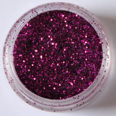 Close-up of vibrant purple glitter eyeshadow with shimmer particles in a sleek compact case