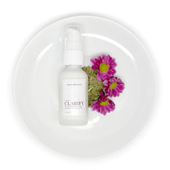 Skincare bottle with white pump, pink flowers, and white plate, teava skincare label visible