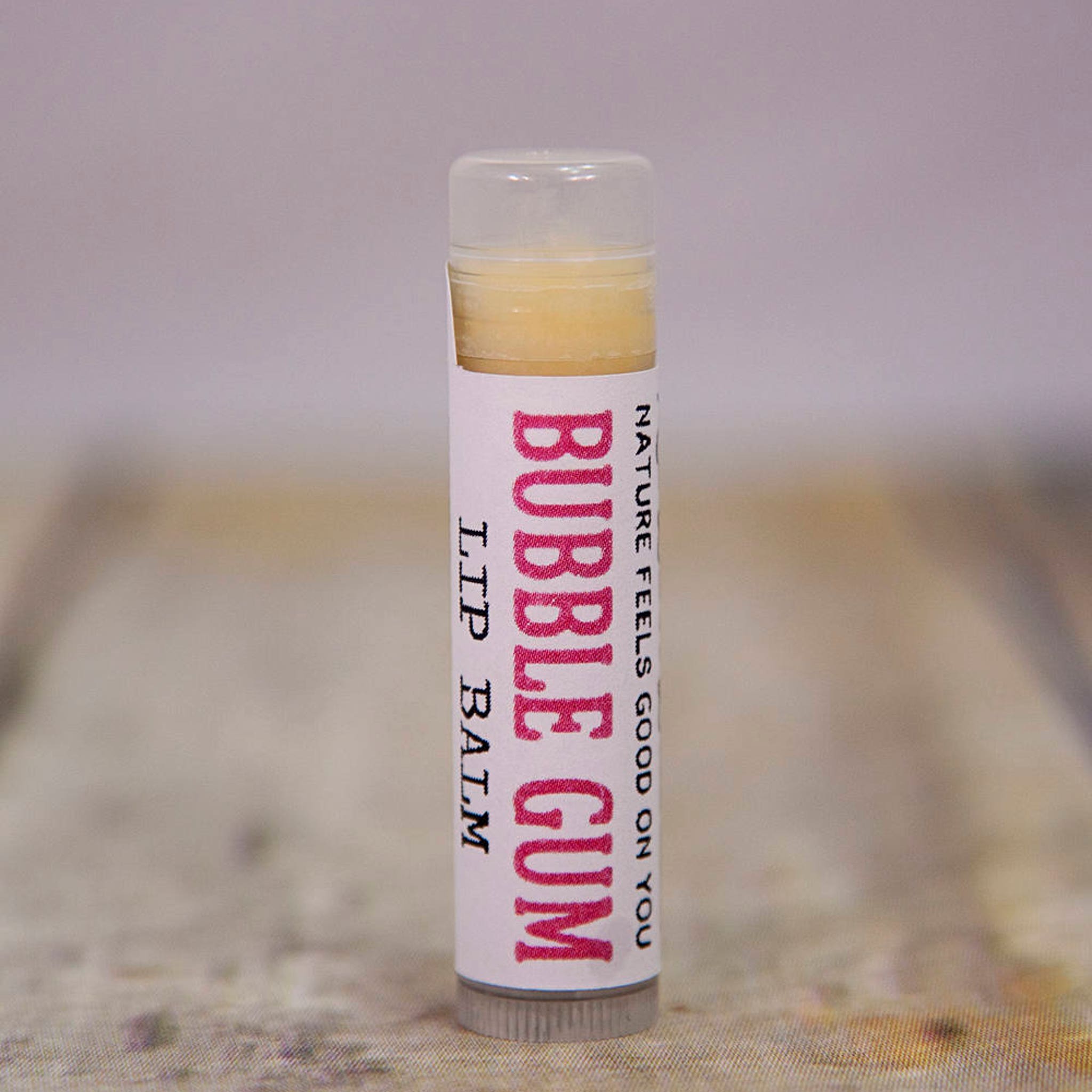 Lip balm tube with clear cap, white label, and Bubble Gum text in pink font