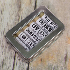 Lip balm set in a silver metal tin with white labels and black text, on a wood background