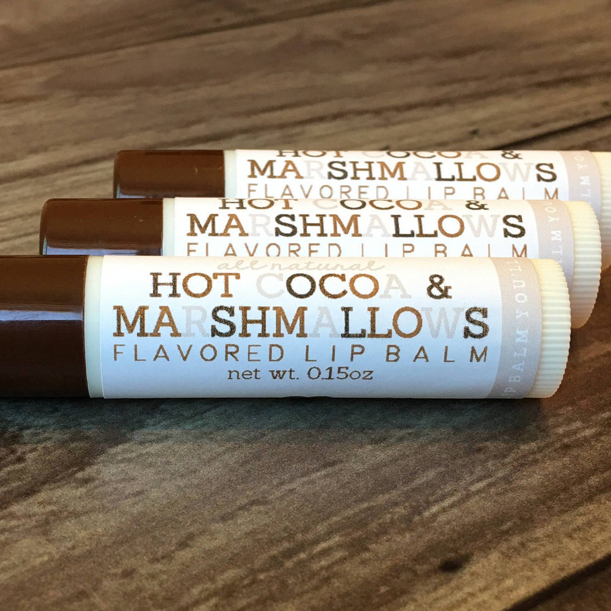 Lip balm tubes with brown caps, white labels, and "Hot Cocoa & Marshmallows" text on them