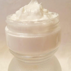 Golden turmeric cream in sleek white jar with minimalist label, showcasing rich texture and earthy tone from side angle