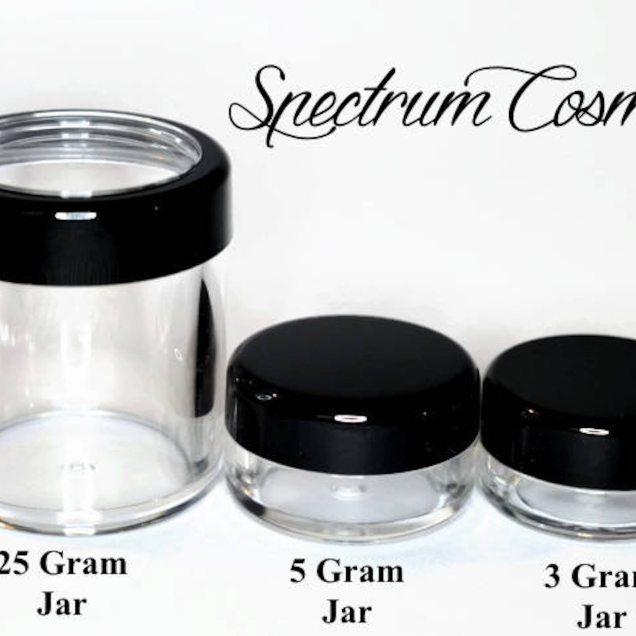 Cosmetic jars with black lids, clear glass, and Spectrum Cosmetics text