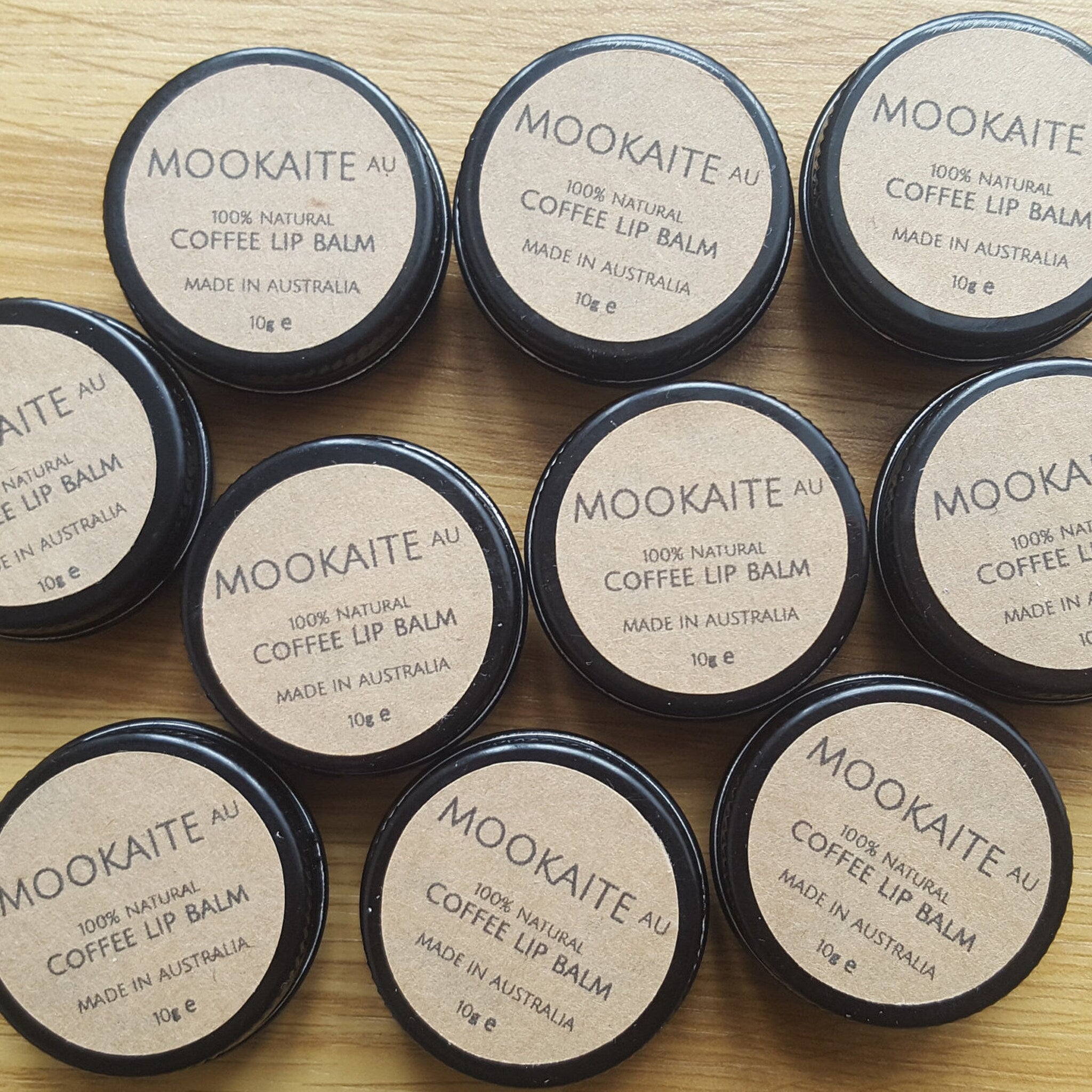 Coffee lip balm tins with brown labels and black lids, Mookaite brand visible