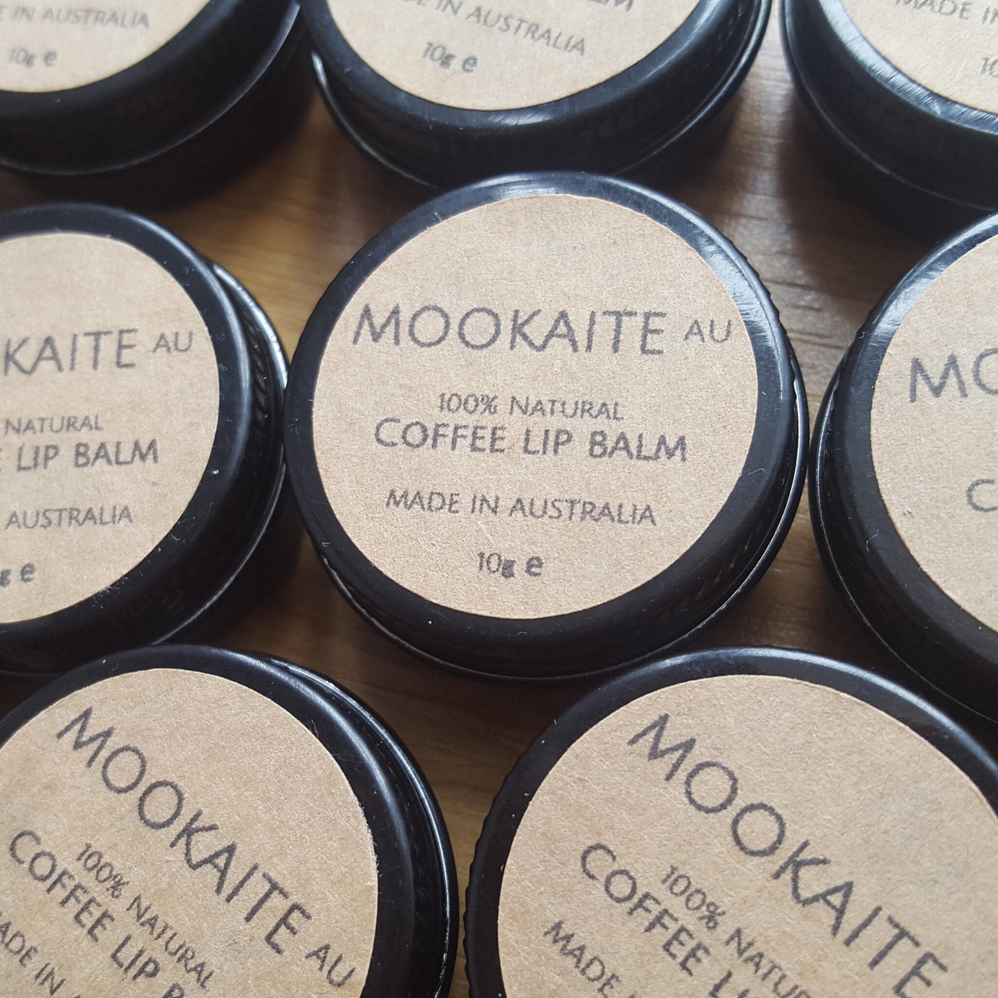 Coffee lip balm jars with black lids and brown labels, Mookaite brand visible