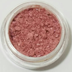 Close-up of soft pink mineral eyeshadow with shimmering pearl finish in compact case