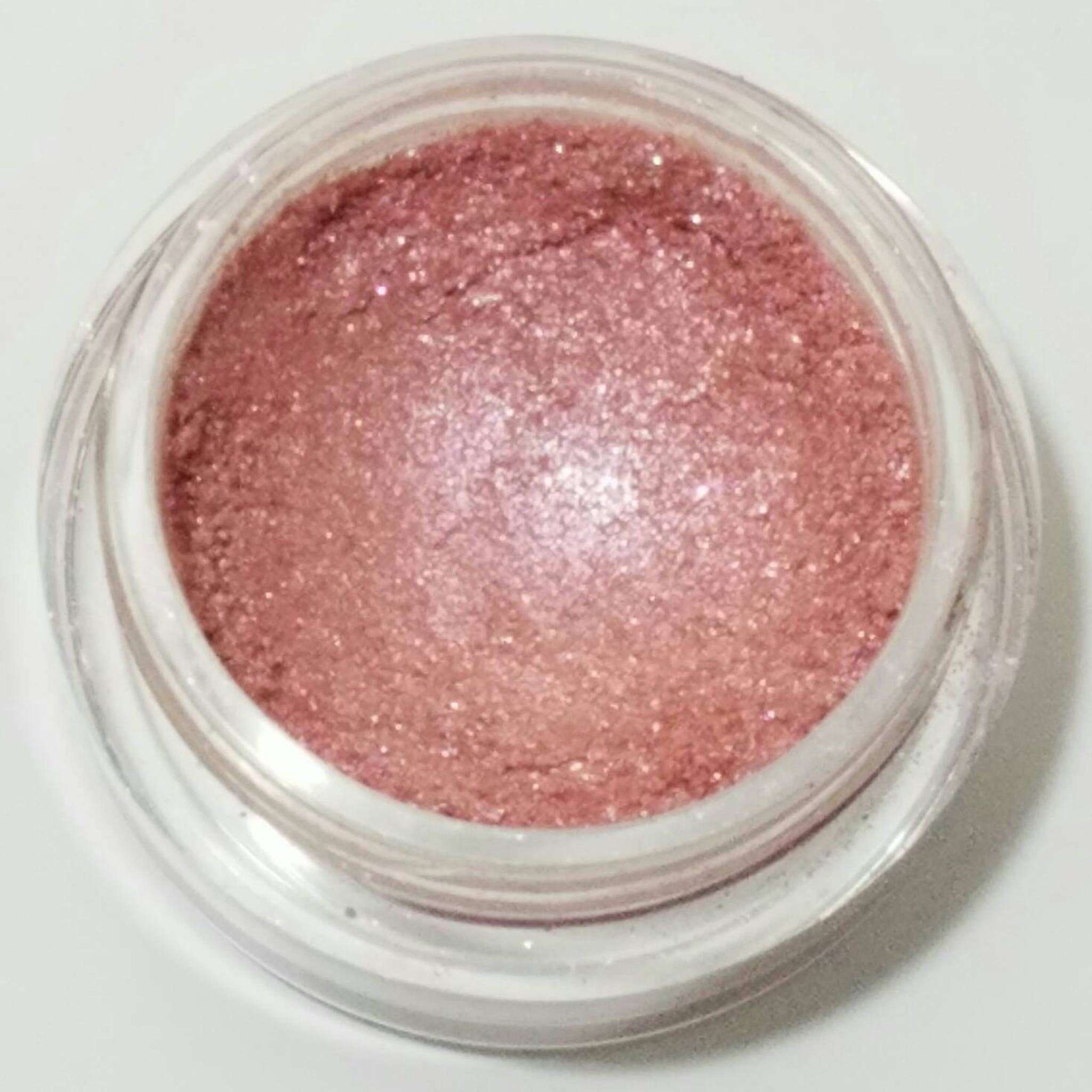 Soft pink mineral eyeshadow in compact case with smooth matte finish and subtle shimmer particles