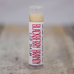 Lip balm tube with clear cap, white label, and red "Blackberry Brandy" text on the tube