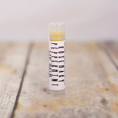 Lip balm tube with white label, clear cap, and yellow balm inside, Rosemary Peppermint text