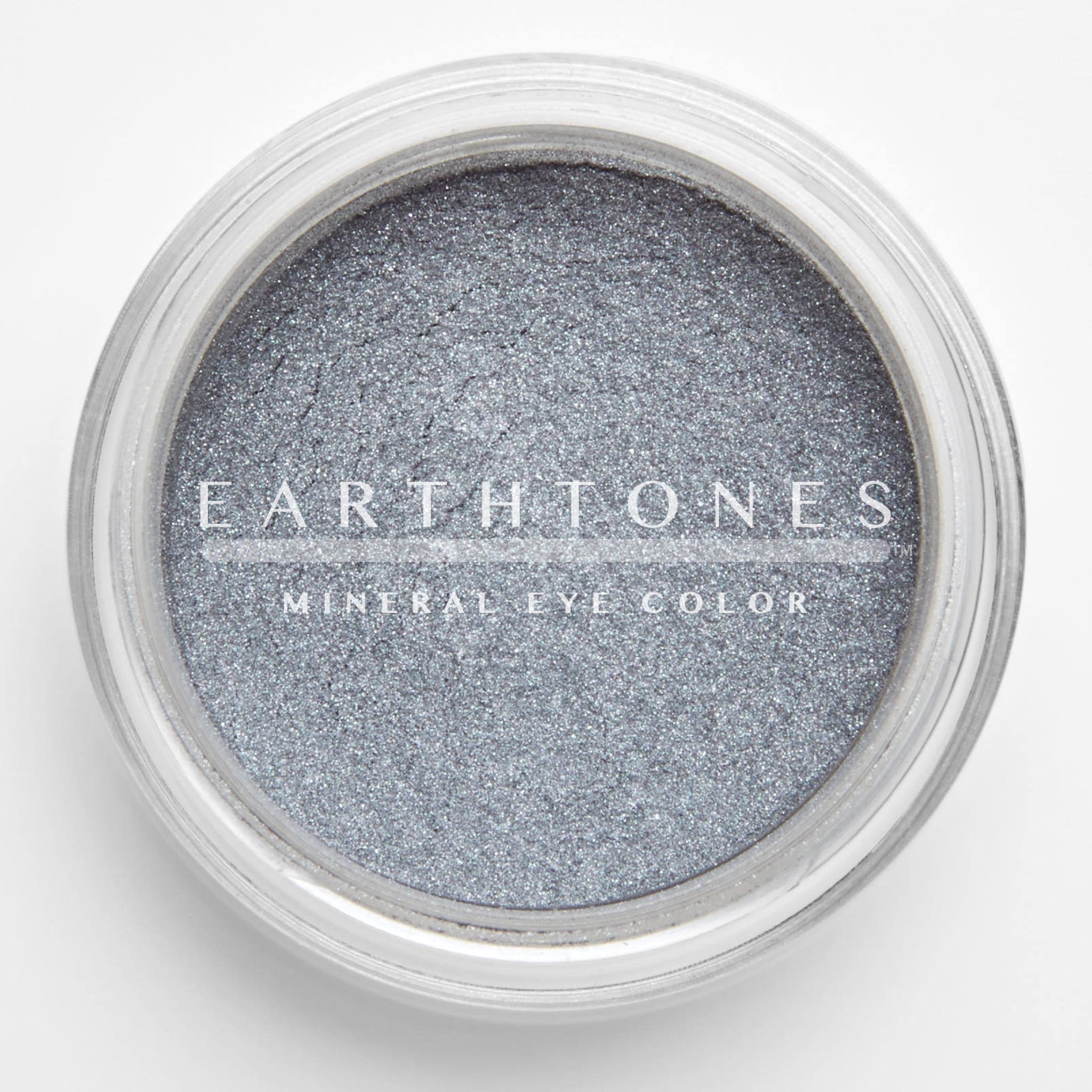 Close-up of shimmering silver mineral eye shadow with finely milled texture in compact case