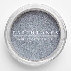 Close-up of shimmering silver mineral eye shadow with finely milled texture in compact case