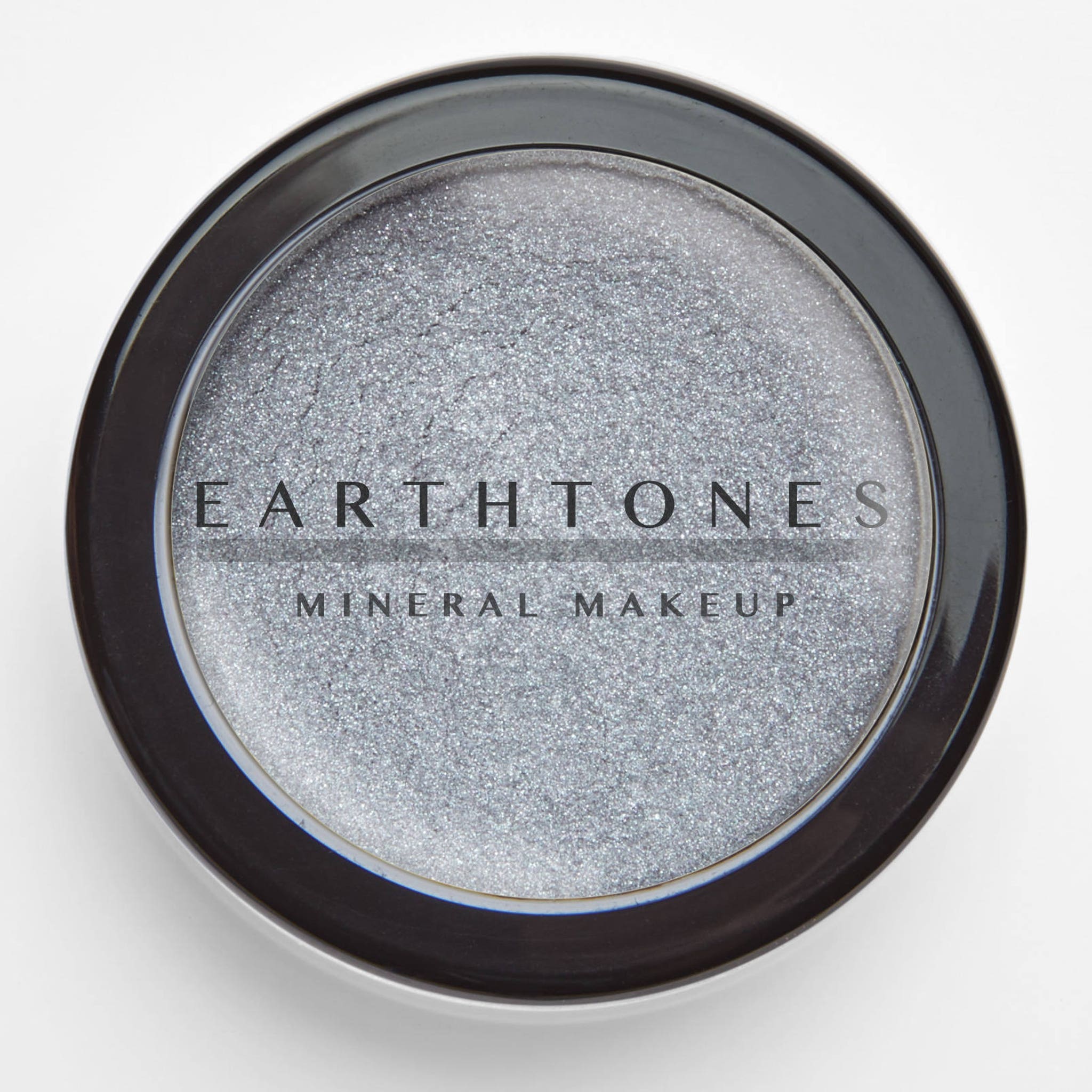 Side view of silver mineral eye shadow compact showing shimmer texture and sleek metallic packaging