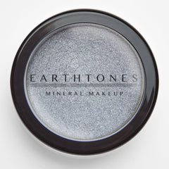 Side view of silver mineral eye shadow compact showing shimmer texture and sleek metallic packaging