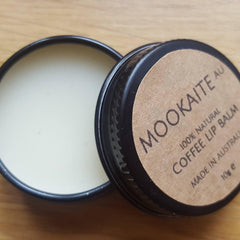 Lip balm in black tin with white cream and brown label, Mookaite brand visible