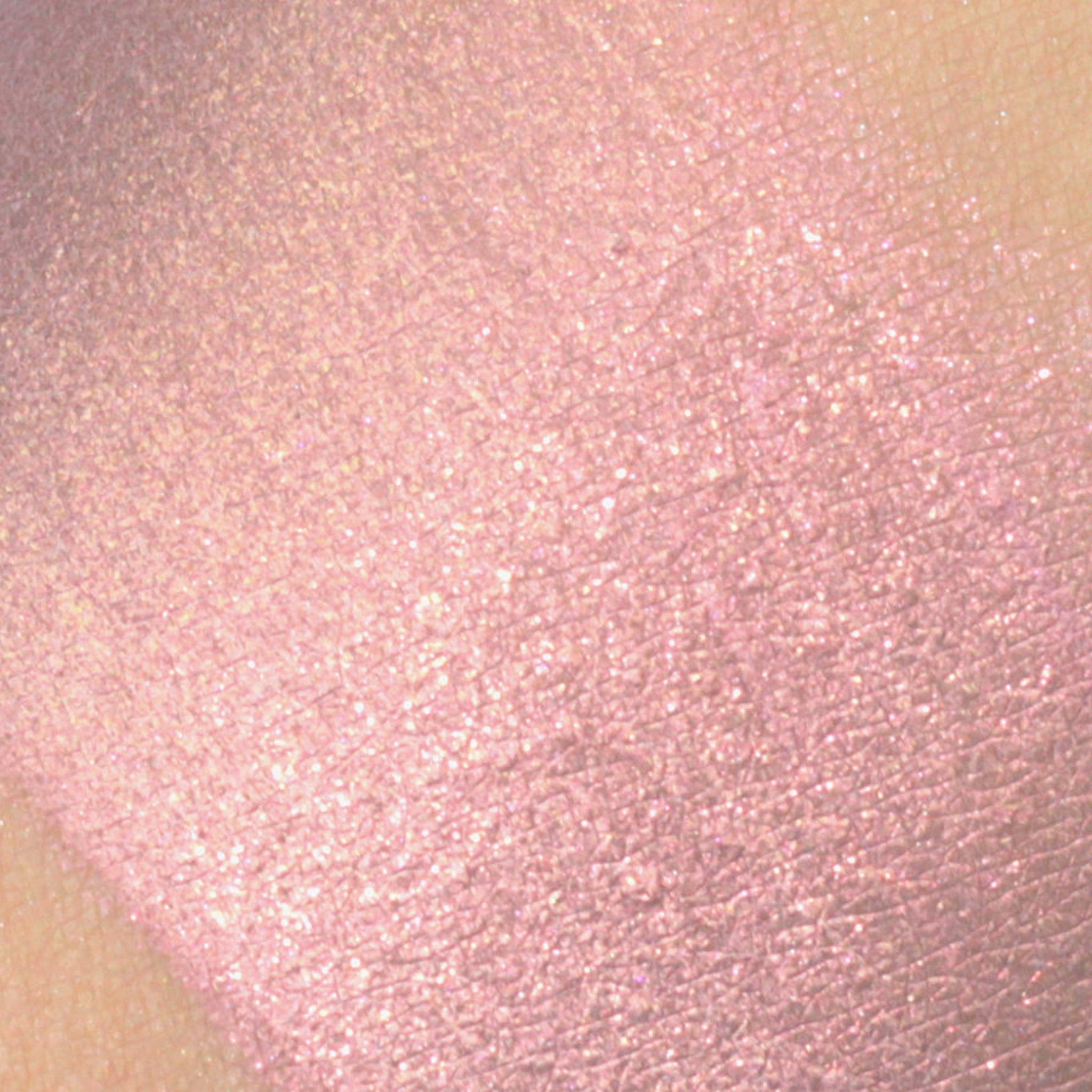 Pink eyeshadow swatch with shimmer and skin texture visible