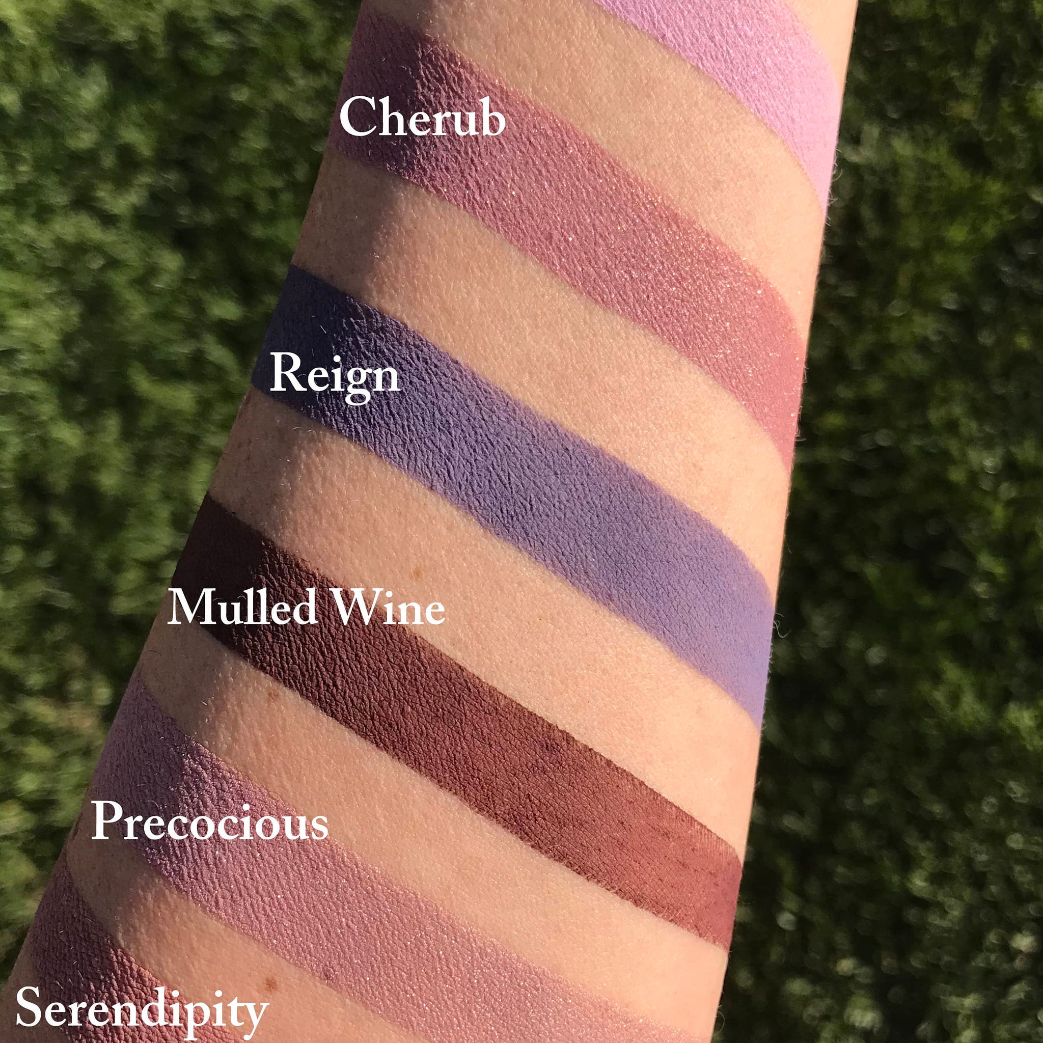 Close-up of vegan eyeshadow palette showing rich pigmented shades in matte and shimmer finishes with dual-ended brush