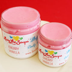 Close-up of rich cherry vanilla whipped body butter in a pink jar with creamy texture and vegan label