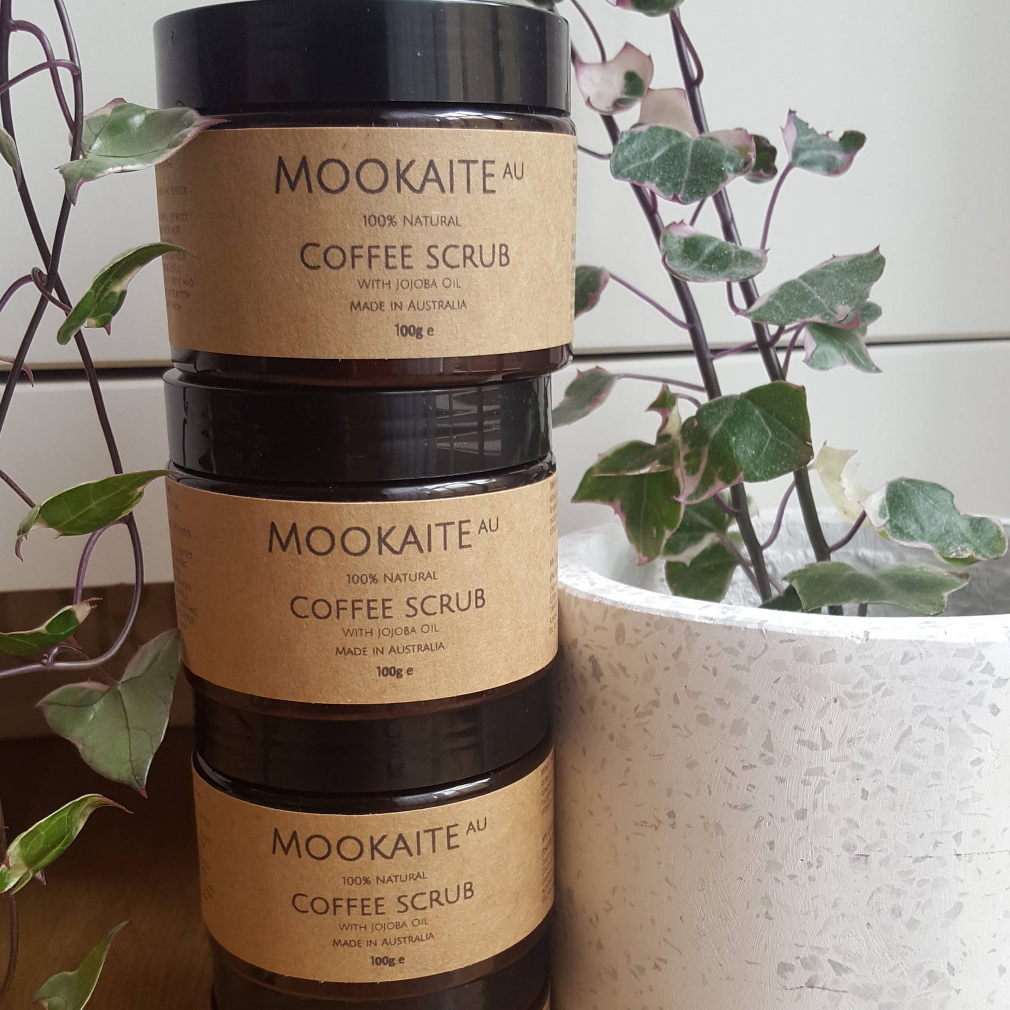 Coffee scrub jars with brown labels, black lids, and MOOKAITE AU text, stacked together