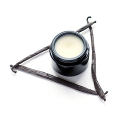 Close-up of golden vanilla moisturizer cream with silky texture in a sleek white jar