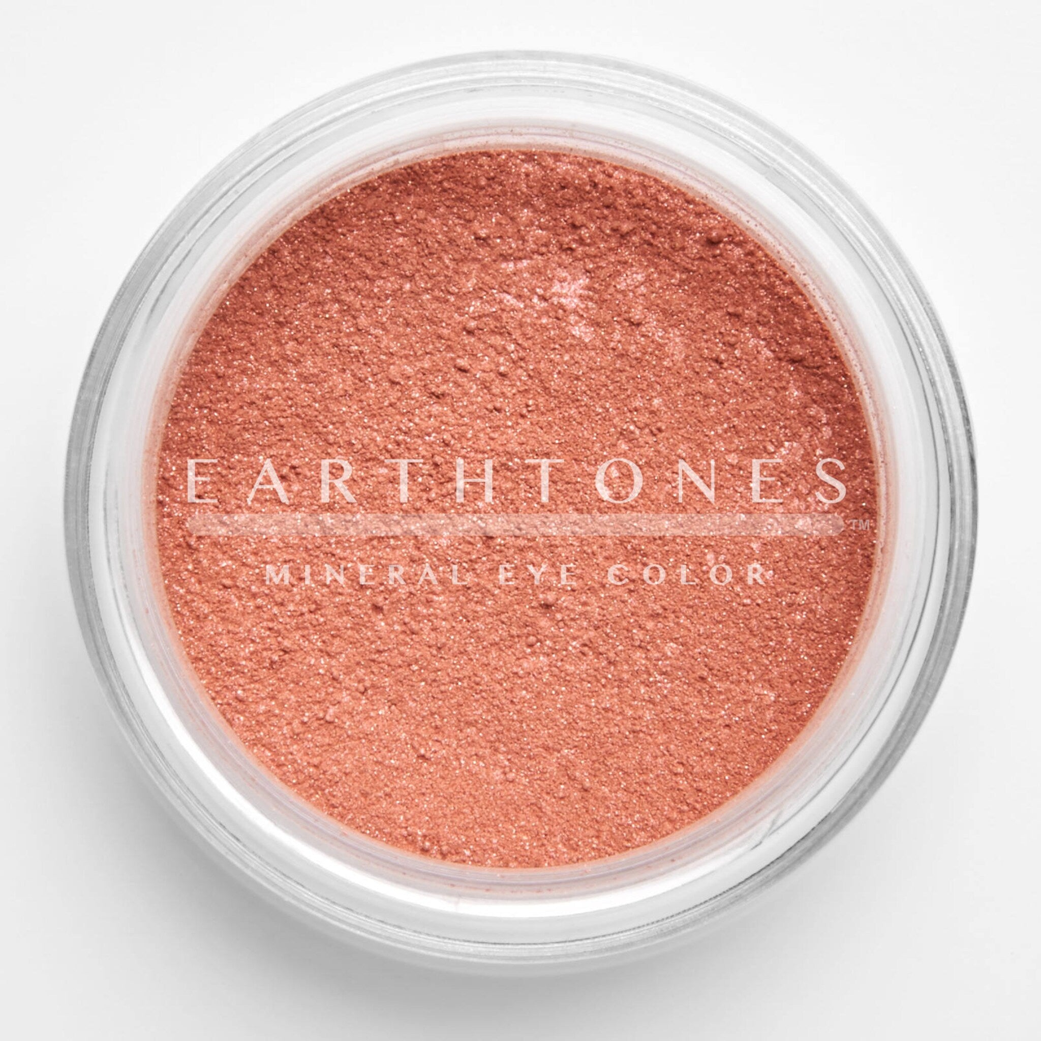 Close-up of shimmery rose pink mineral eye shadow with sparkling flecks in compact pan