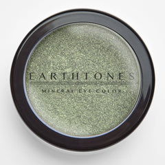 Close-up of fingertips applying mint shimmer mineral eye shadow to eyelid, showcasing soft shine finish