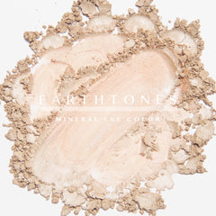 Woman applying peach shimmer mineral eye shadow to eyelid with soft brush for a glowing makeup look