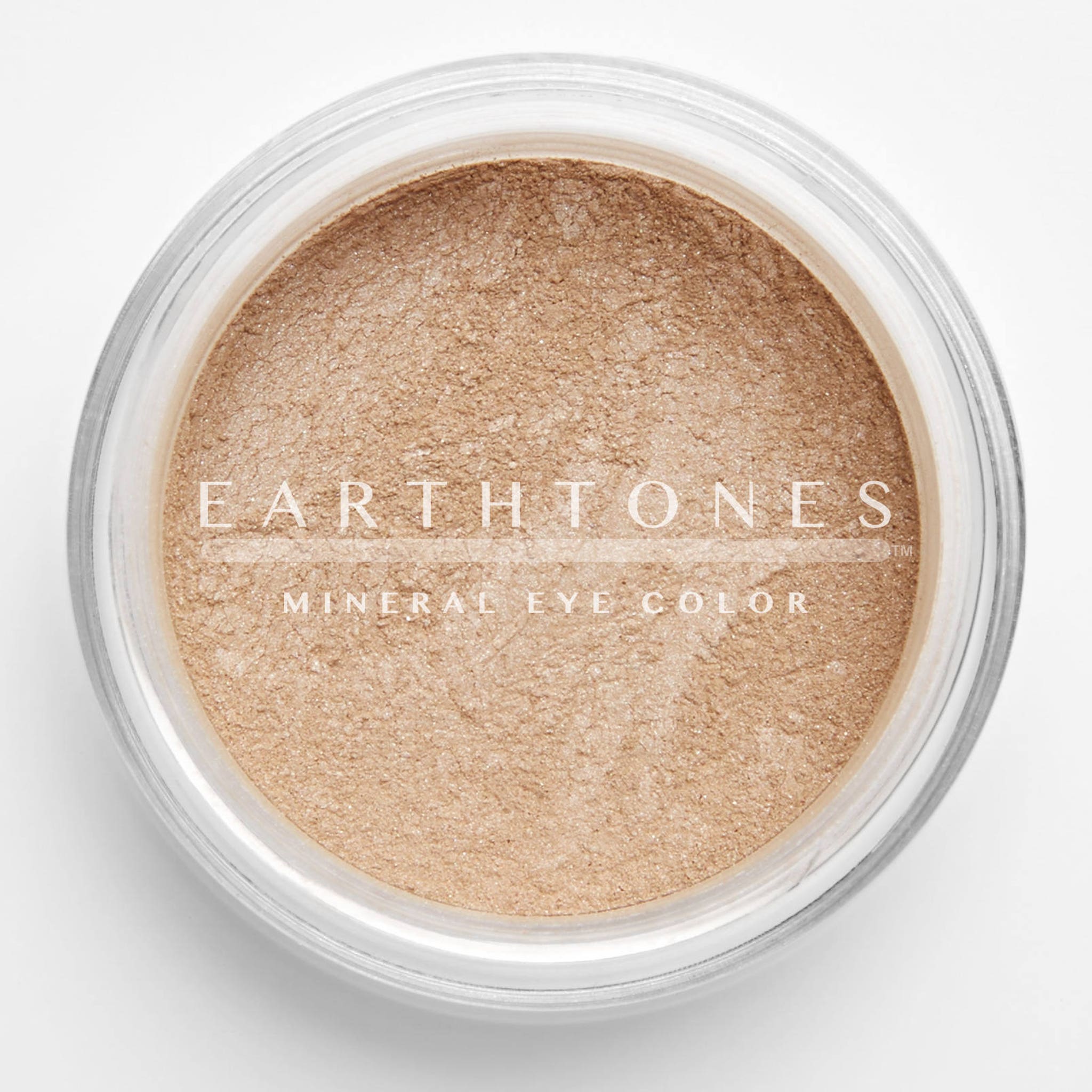 Close-up of peach shimmer mineral eye shadow with sparkling flecks in compact pan