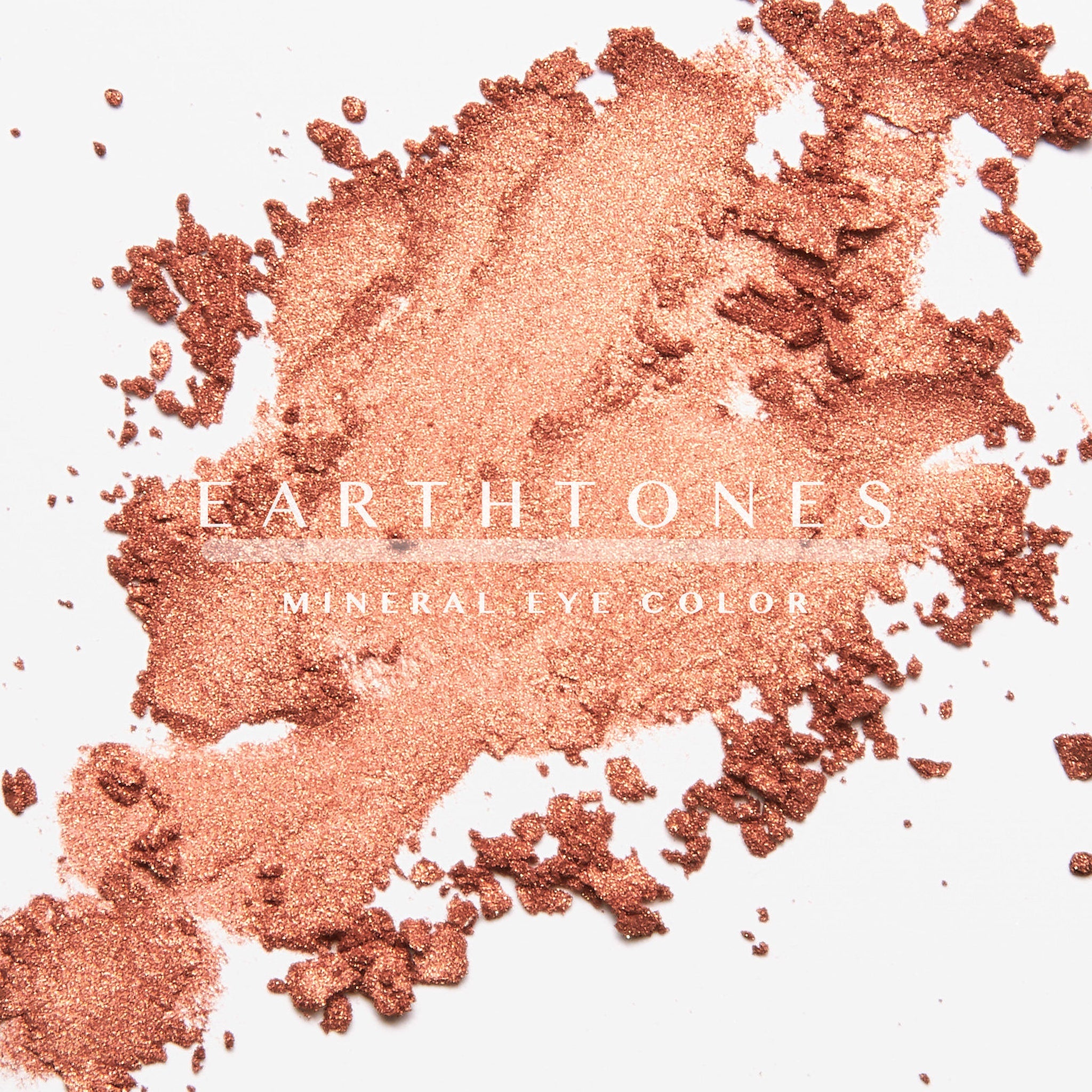 Hand applying copper shimmer eye shadow with fingertip to eyelid for a warm metallic glow