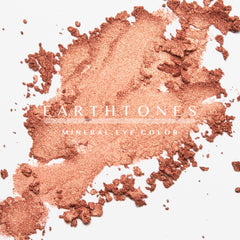 Hand applying copper shimmer eye shadow with fingertip to eyelid for a warm metallic glow
