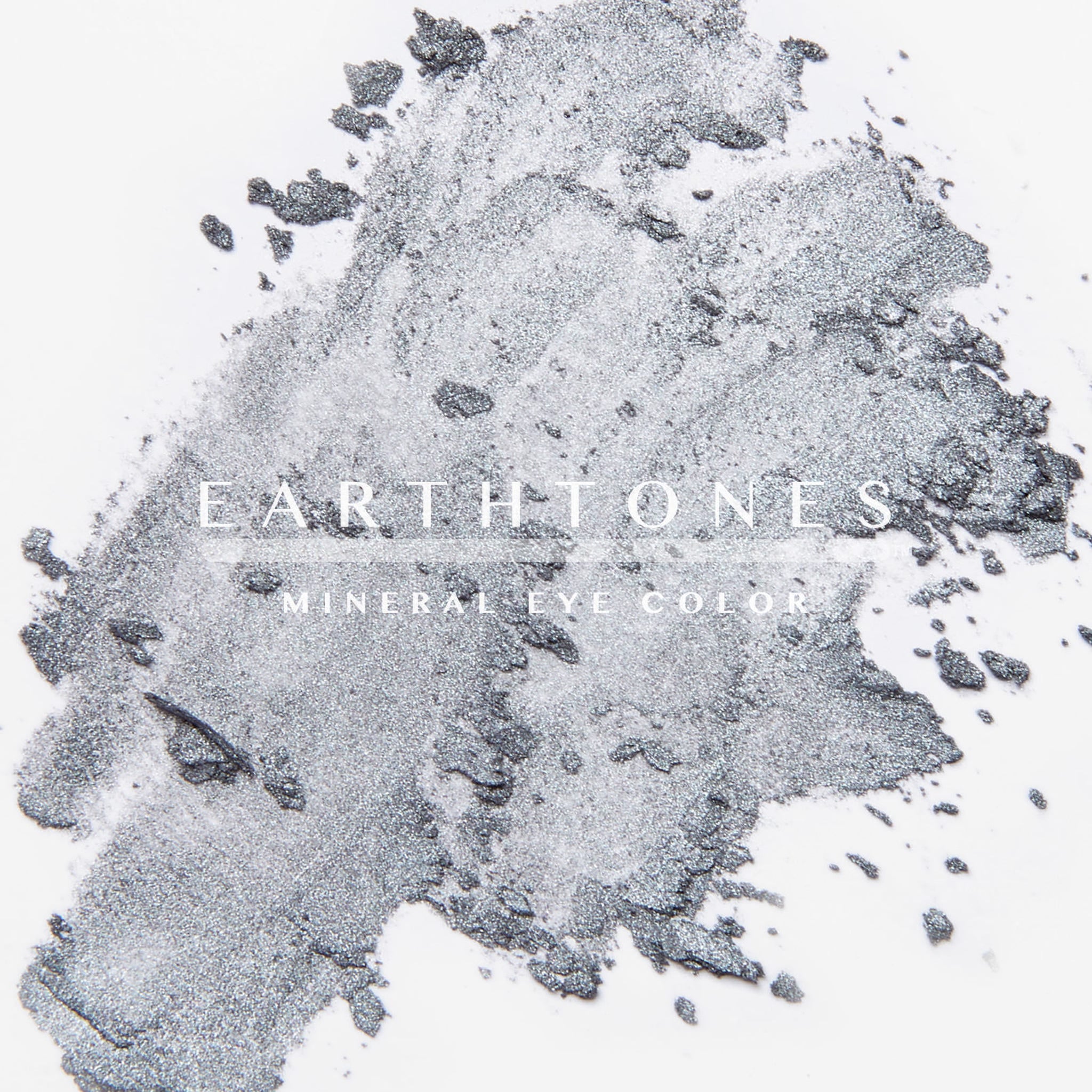 Woman applying shimmering silver mineral eye shadow to eyelid with fingertip for a metallic finish