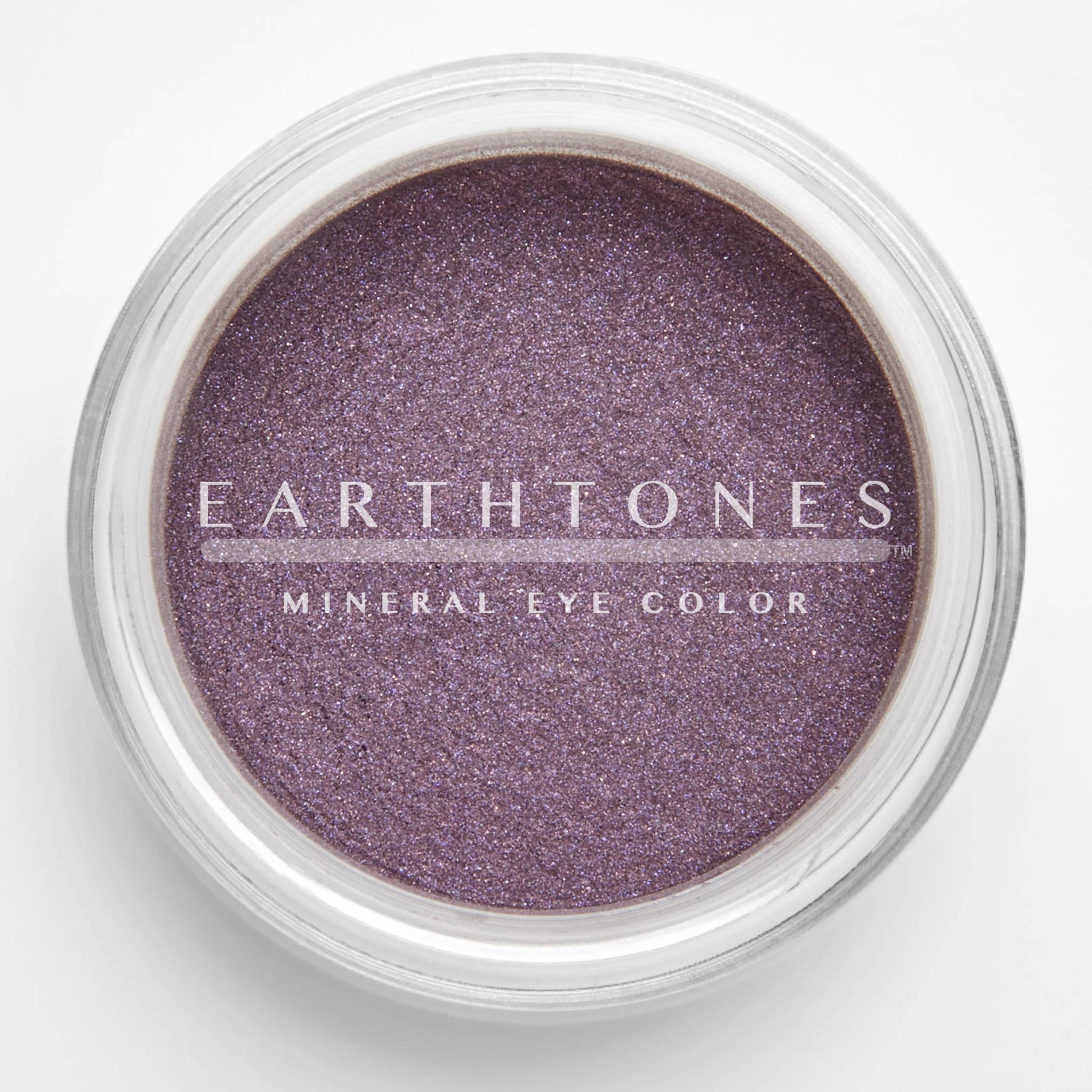 Close-up of rich plum mineral eyeshadow with shimmering metallic finish in compact case