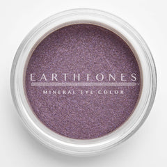 Close-up of rich plum mineral eyeshadow with shimmering metallic finish in compact case
