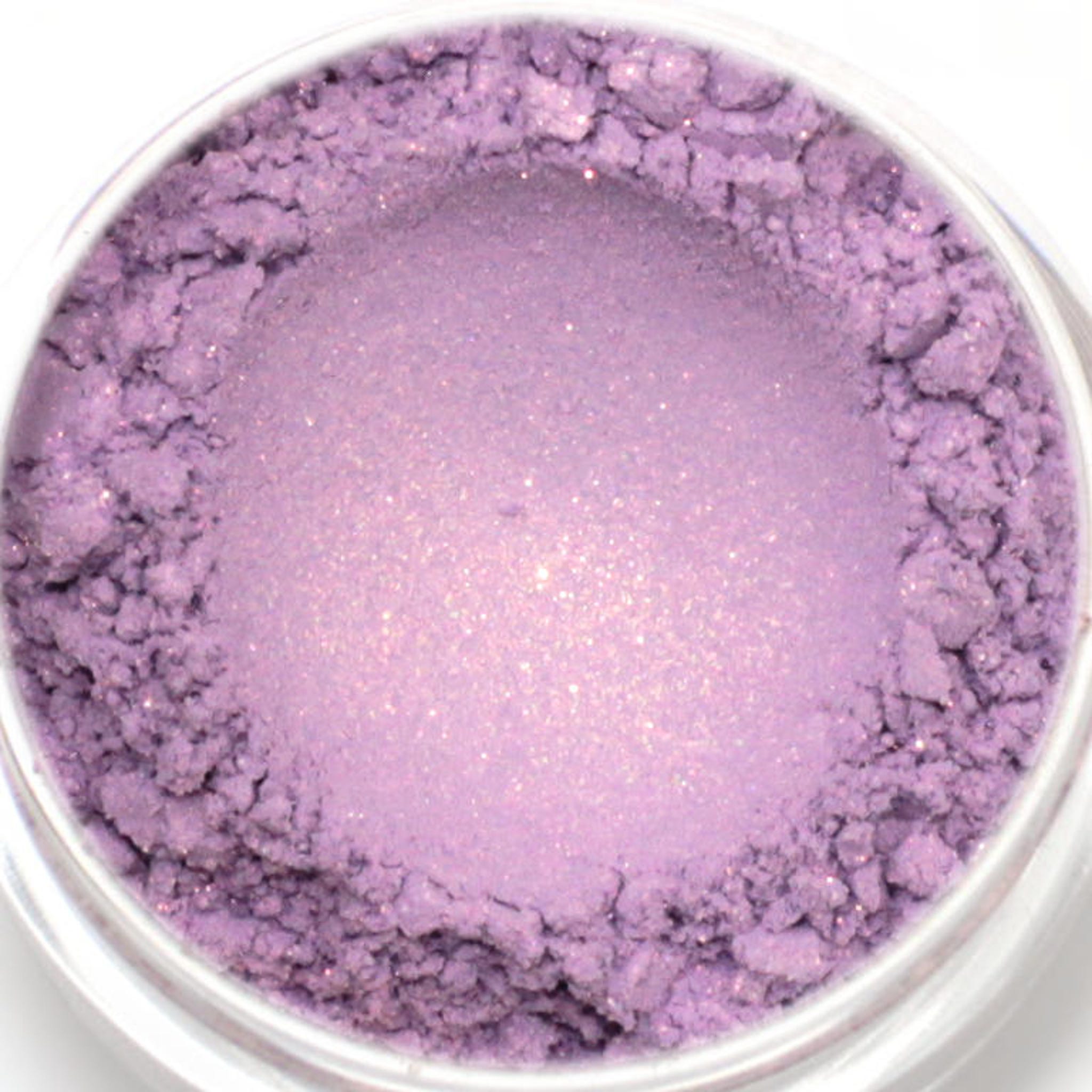 Eyeshadow powder in lavender color with shimmery finish in a clear jar, close-up view