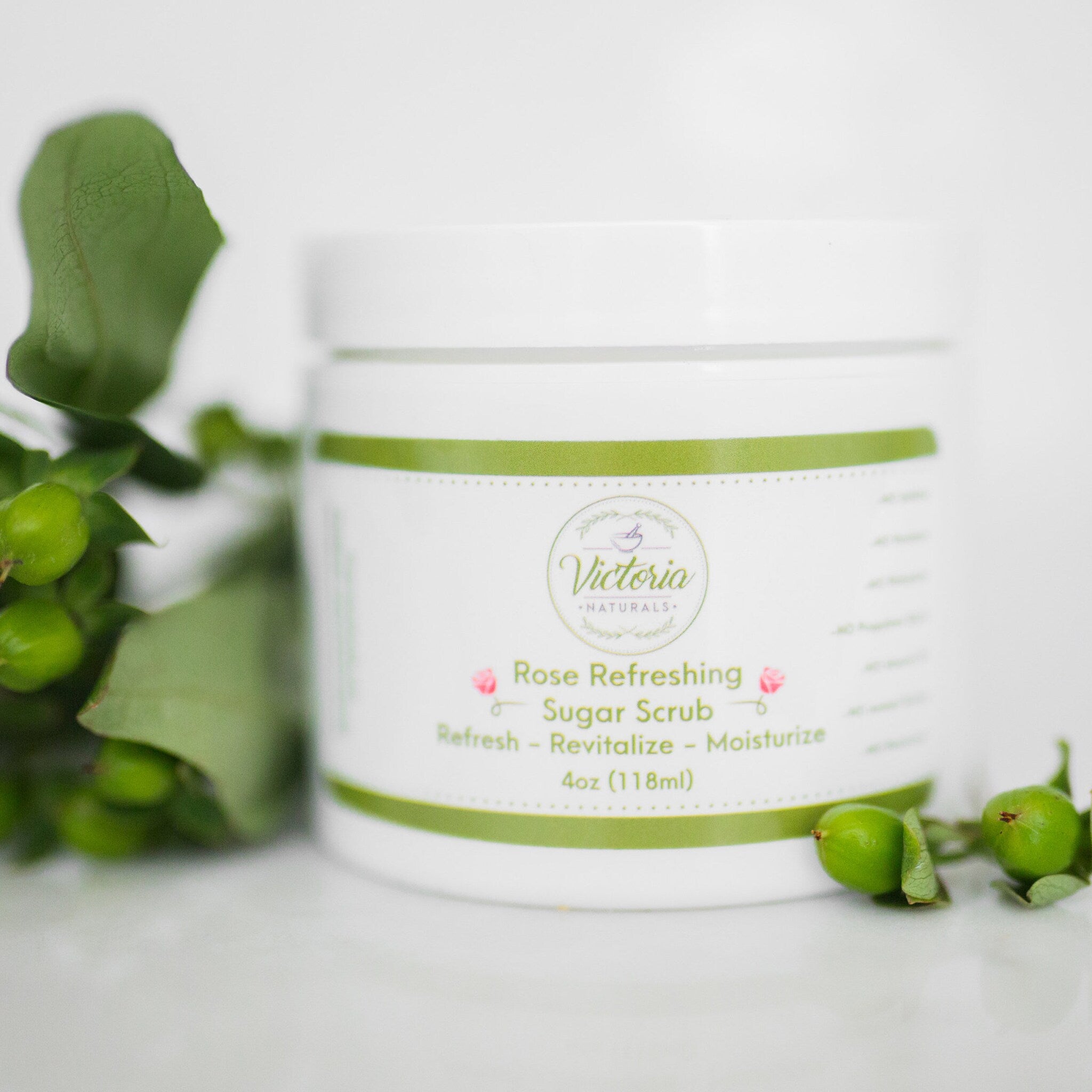 Sugar scrub jar with white and green label, green accent, and Victoria Naturals branding with green leaves
