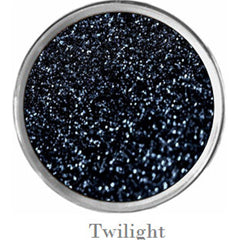 Close-up of fingers applying sparkly teal eyeshadow from vegan palette with black and purple shades