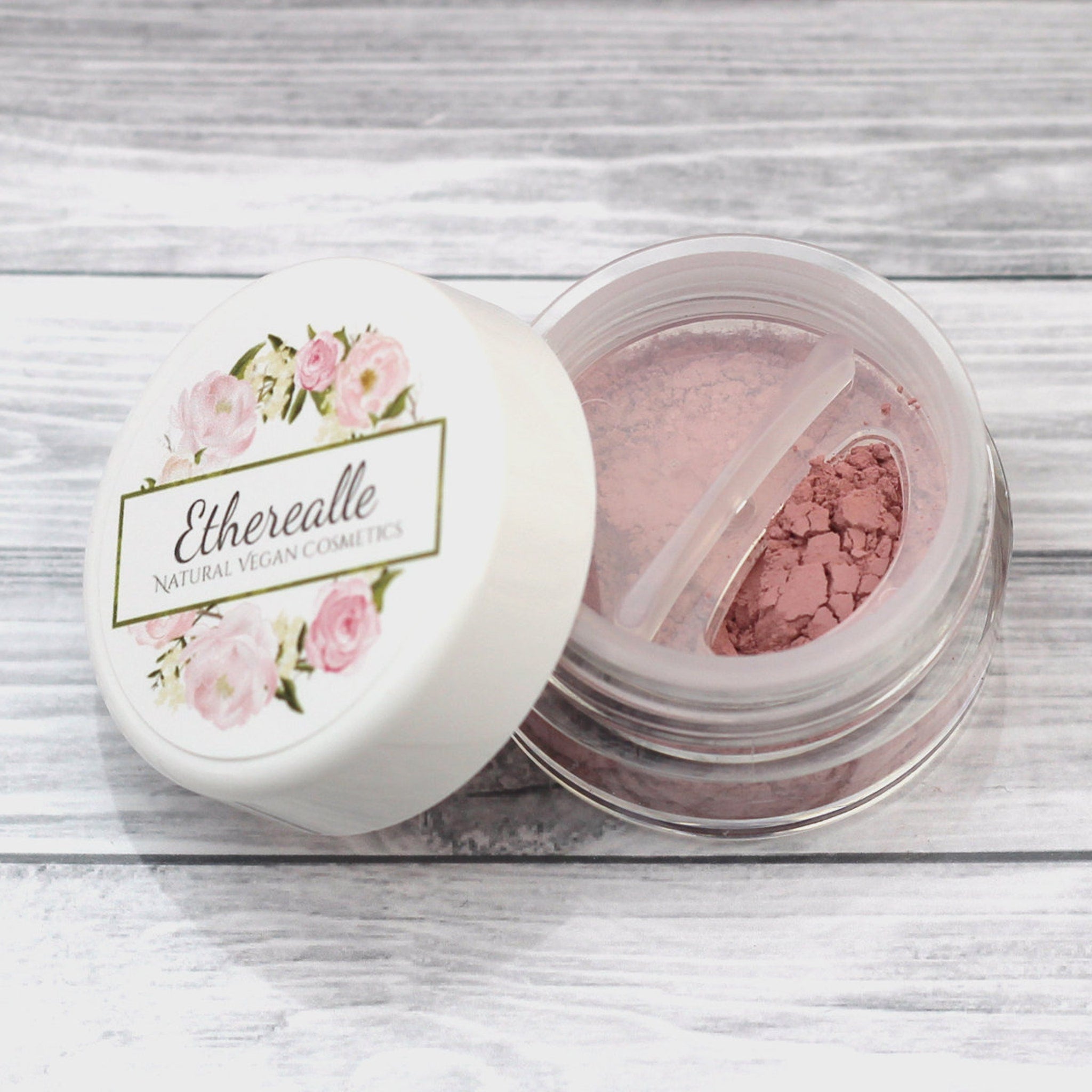 Close-up of matte light pink vegan mineral eyeshadow in compact with smooth, velvety texture and subtle sheen