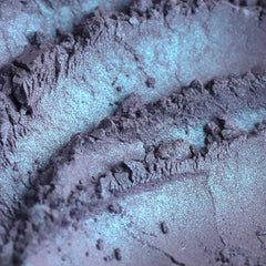 Iridescent powder with blue and purple hues, textured surface, for eyeshadow application