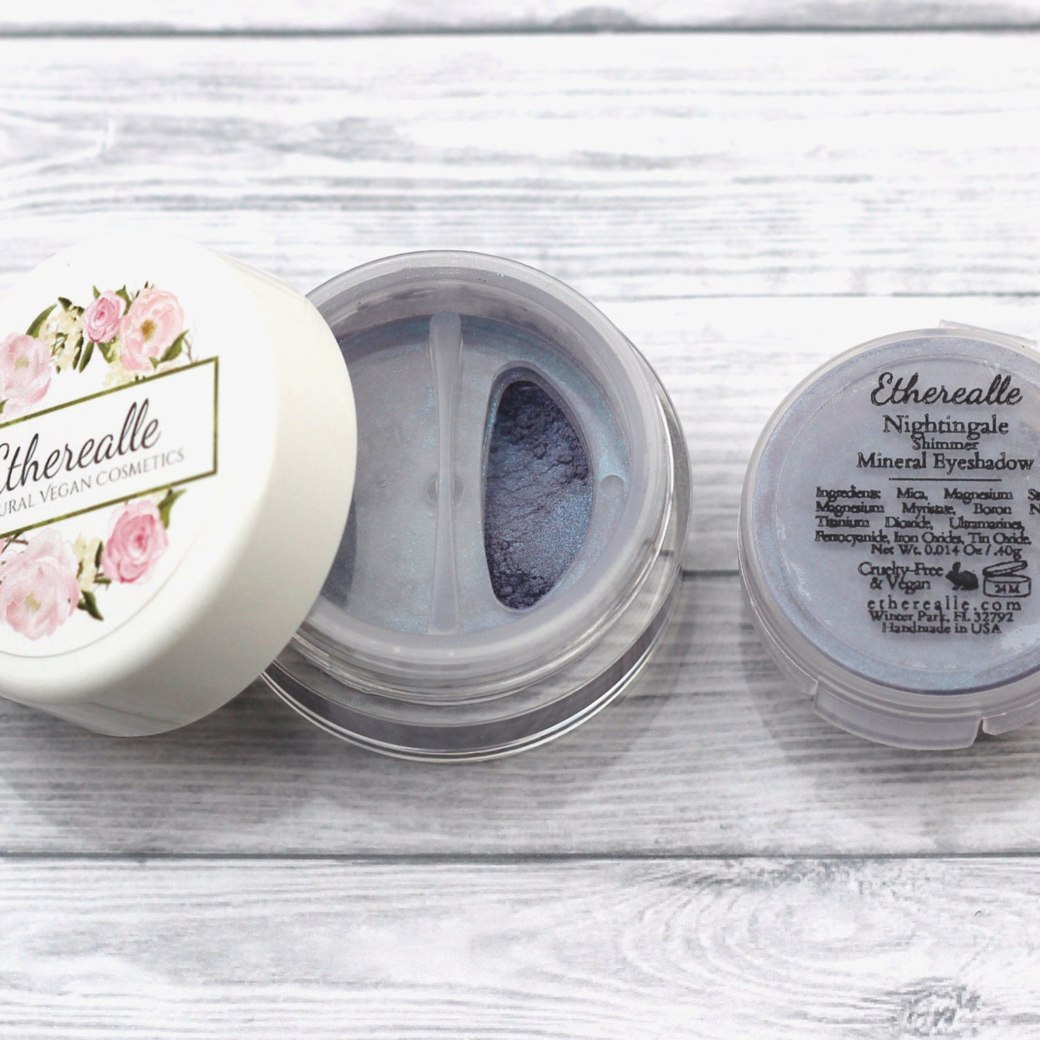 Eyeshadow pot with Etherealle branding, white and clear plastic, blue shimmer powder inside
