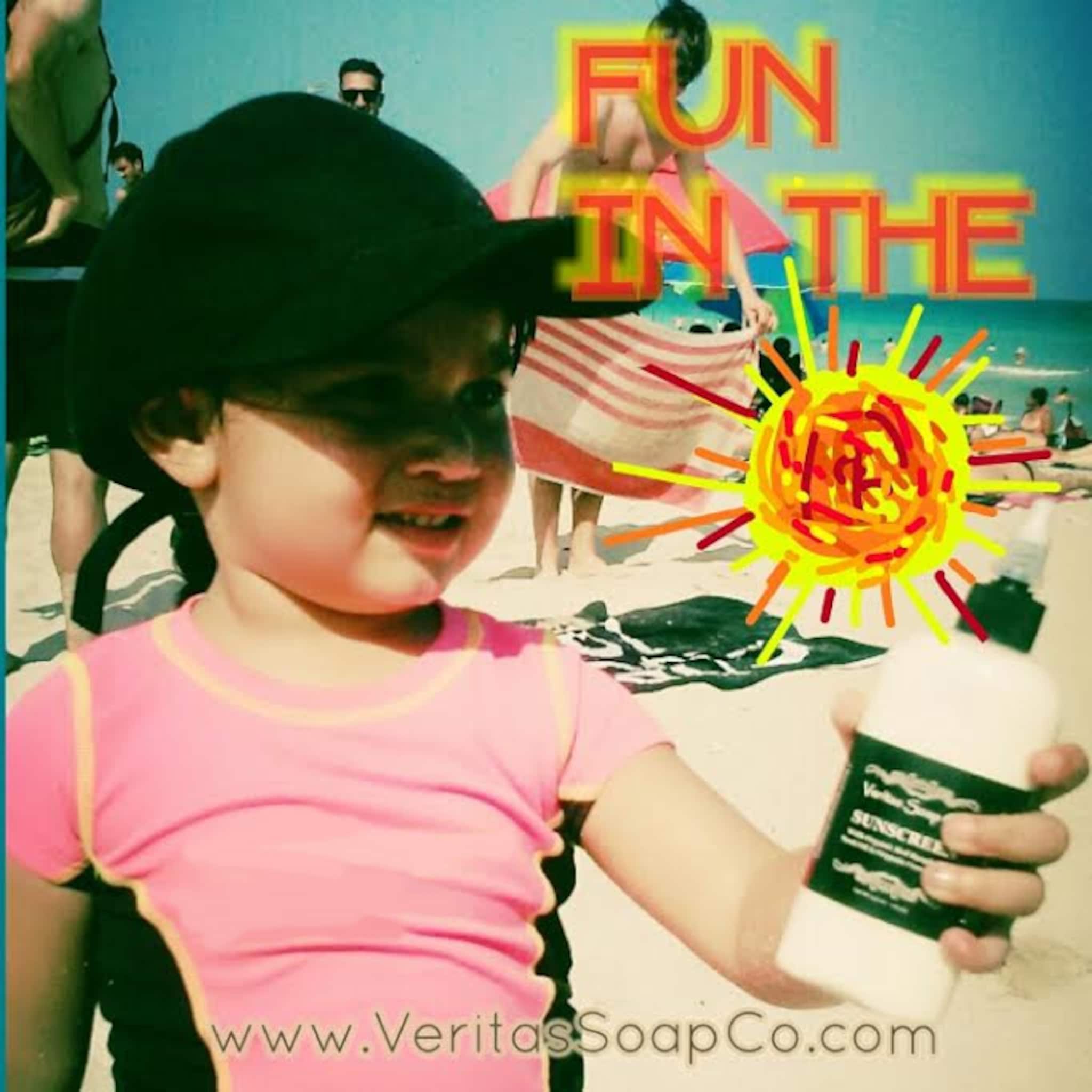 Sunscreen bottle held by child, white bottle with green label, Veritas Soap Co. brand text visible