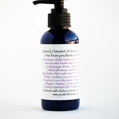 Pump bottle with black pump and navy blue glass, white label with text visible